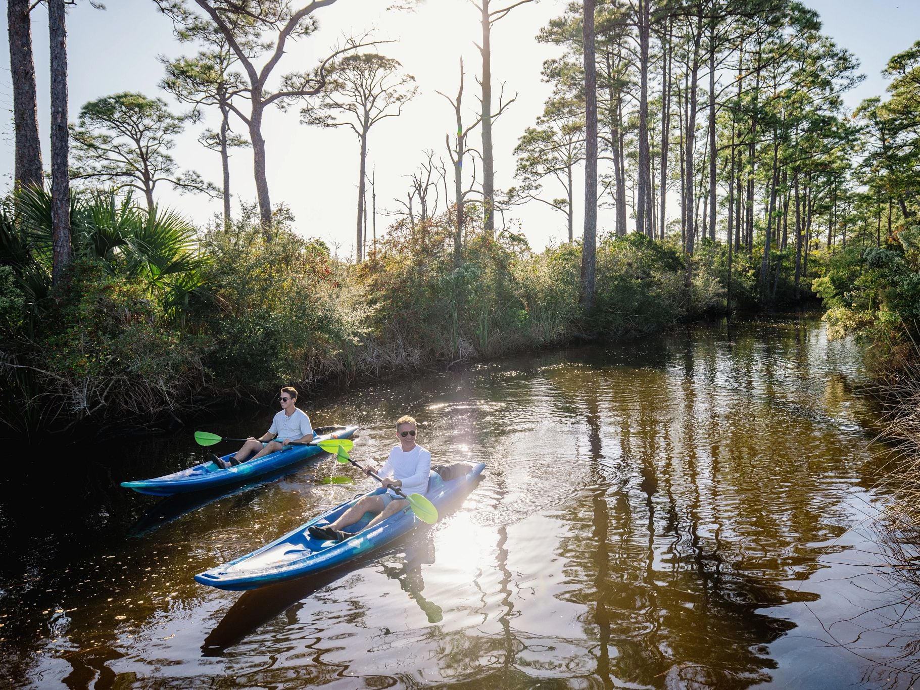 Two kayakers paddling along the back bays in Orange Beach