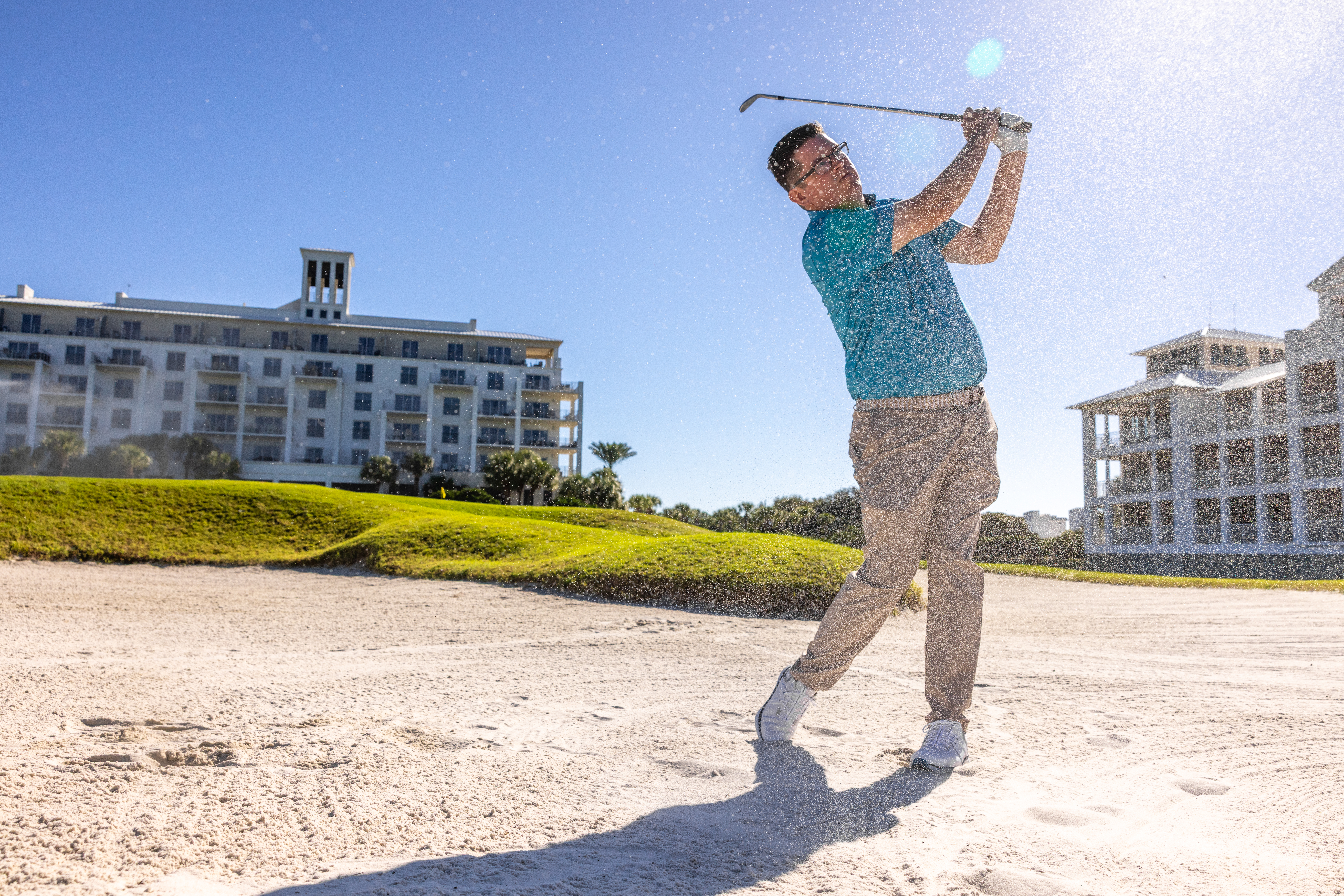 Golfer hitting a ball out of a sand trap at Kiva Dunes Golf Resort