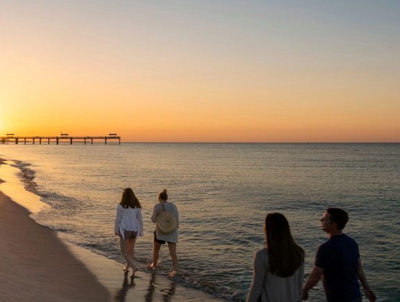 Family walking along the beach at sunset