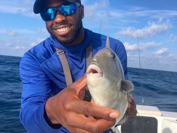 Angler holding a triggerfish caught on an inshore charter in Oragne Beach