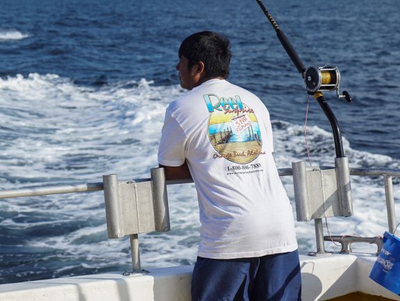 Man on back of boat trolling inthe Gulf of Mexico