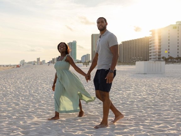 Couple walking on the beach at sunset in Orange Beach