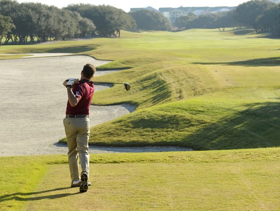 Golfer swinging at Kiva Dunes Golf Resort in Fort Morgan