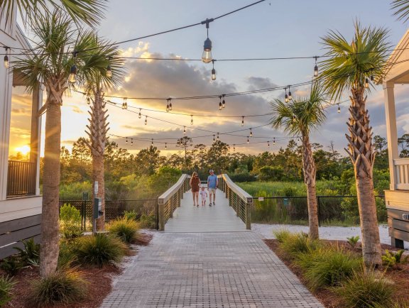 Family walking on the boardwalk leading to Gulf State Park from Beach Village Resort