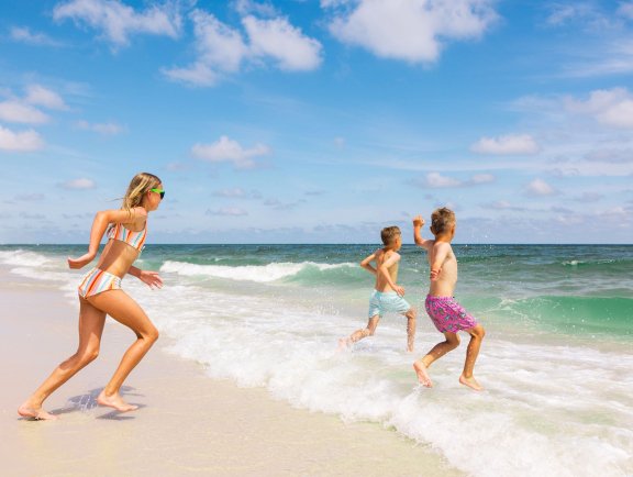 Kids running into the Gulf on the beach in Gulf Shores