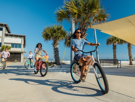Friends biking at Gulf Place Public Beach in Gulf Shores