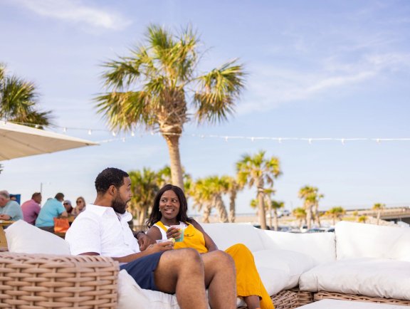 couple dining on the couches at The Gulf beachfront restaurant in Orange Beach