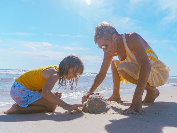 grandma and grandkid playing on the beach in gulf shores