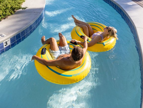Couple floating on a lazy river at Phoenix West beachfront condo in Orange Beach