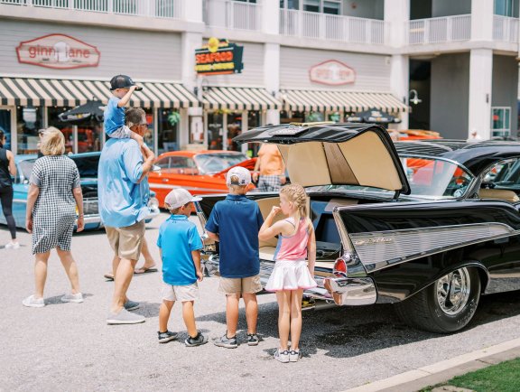 Kids admiring a classic car at the Bama Coast Cruisin' Car Show at The Wharf