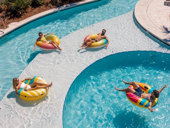Friends floating on inner tubes in the lazy river at Beach Village Resort in Oragne Beach