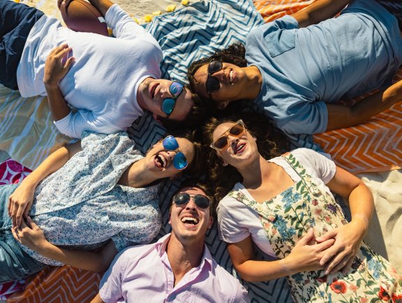 Friends hanging out on blankets on the beach in Gulf Shores