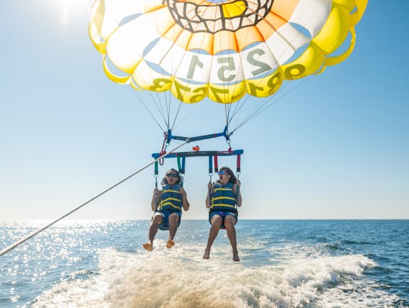 Friends parasailing over the Gulf in Orange Beach