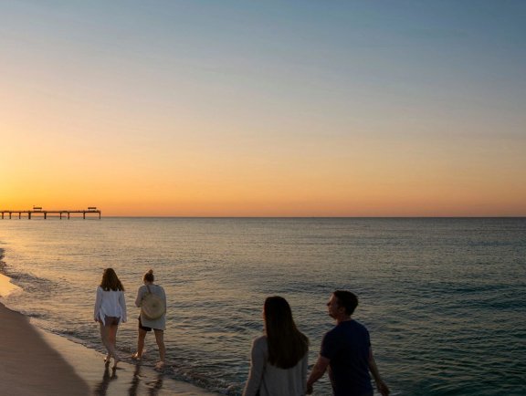 Family walking along the beach at sunset in Gulf Shores
