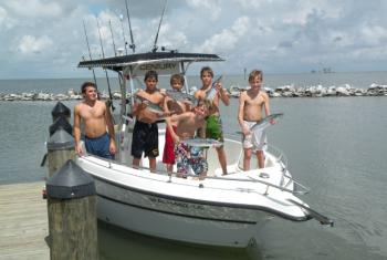Boys holding catch on boat