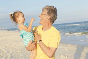 Man holding baby on Gulf Shores Al beach