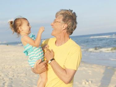 Man holding baby on Gulf Shores Al beach