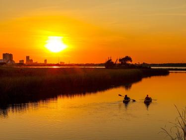 Couple kayaking at sunset in Gulf Shores, AL