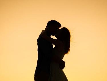 Couple kissing at sunset on Alabama's beaches