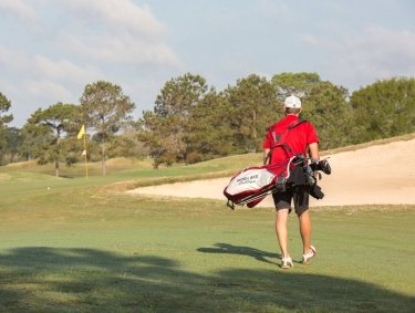 Golfer walking across the green at Craft Farms Golf Resort in Gulf Shores