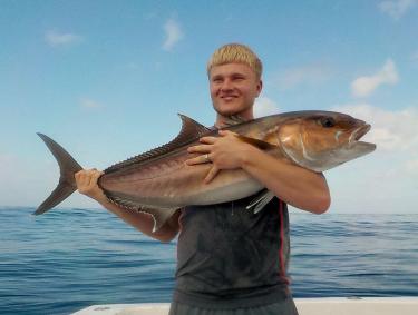 Angler holding an amberjack caught in the Gulf of Mexico
