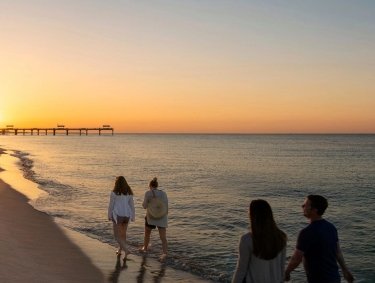 Family walking along the beach at sunset