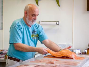 Man holding fresh seafood at Blalock Seafood in Orange Beach