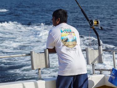 Man on back of boat trolling inthe Gulf of Mexico