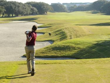 Golfer swinging at Kiva Dunes Golf Resort in Fort Morgan