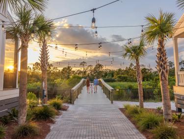 Family walking on the boardwalk leading to Gulf State Park from Beach Village Resort