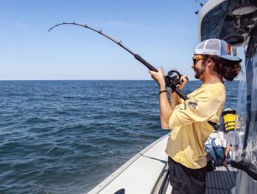 Man fishing off the side of an offshore charter in Orange Beach