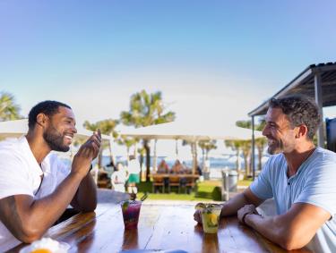 Two men sitting at a table outside at The Gulf waterfront restaurant in Orange Beach