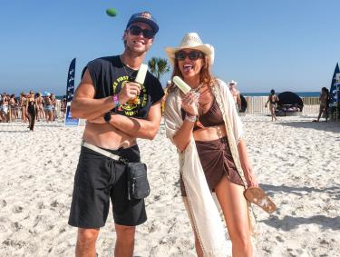 Two festival goers with popsicles on the beach during Sand in My Boots Music Fest in Gulf Shores