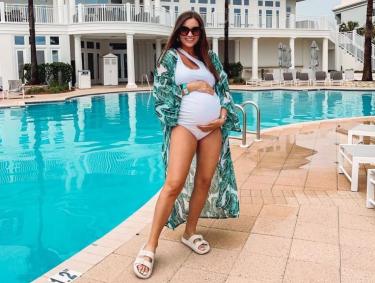 Blogger Erin Moody standing next to the pool at Beach Club Resort in Fort Morgan