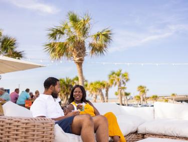 couple dining on the couches at The Gulf beachfront restaurant in Orange Beach