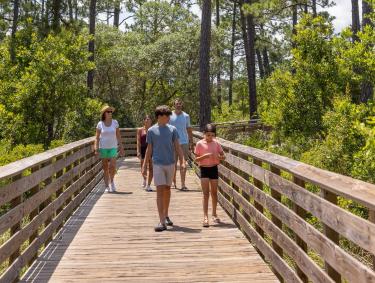 family walking along boardwalk trail in gulf state park