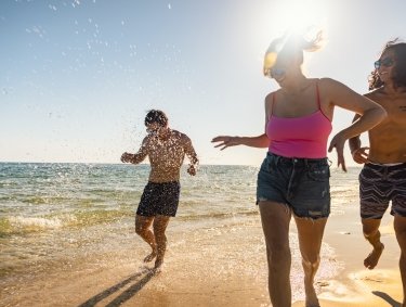 Friends splashing in the water on the beach in Gulf Shores