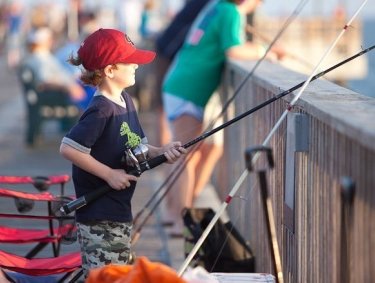 Kid fishing off the Gulf State Park Pier in Gulf Shores