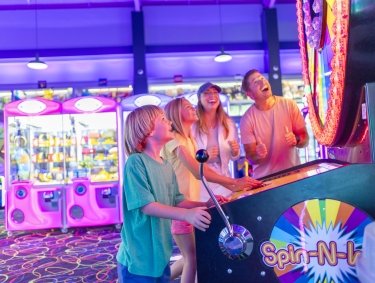 Family playing in the arcade at The Track go-kart attraction in Gulf Shores
