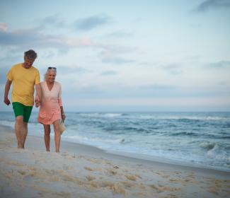 Older couple walking along Orange Beach
