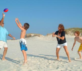 Famiy playing football on Alabama's beaches