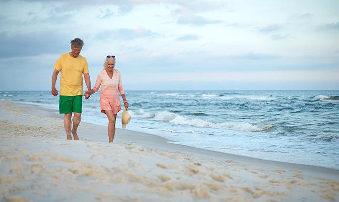 older Couple walks along Alabama's beaches