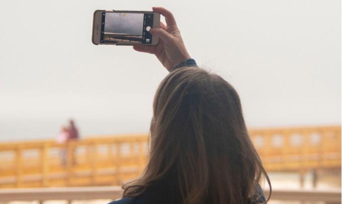 Meeting attendee snapping a picture of Alabama's beaches for social media