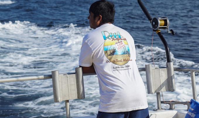 Man on back of boat trolling inthe Gulf of Mexico