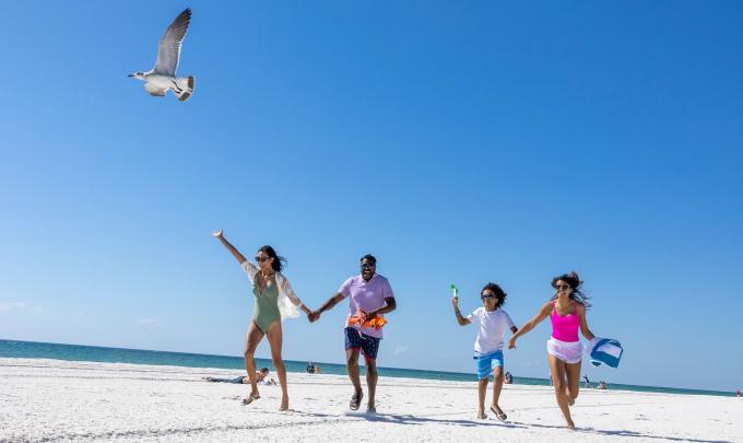 Family running on the beach at Gulf Place, public beach in Gulf Shores
