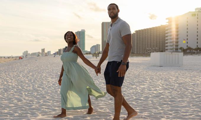 Couple walking on the beach at sunset in Orange Beach