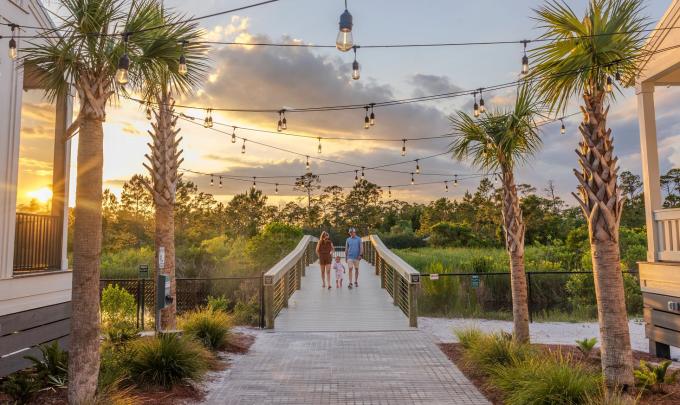 Family walking on the boardwalk leading to Gulf State Park from Beach Village Resort