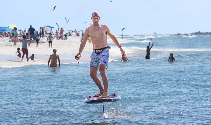 Man riding a foil board near the shore in Orange Beach