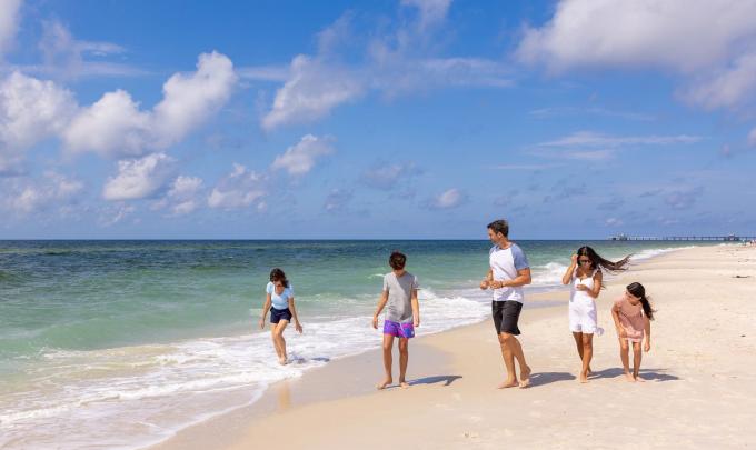 Family walking together along the shore in Orange Beach