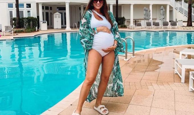 Blogger Erin Moody standing next to the pool at Beach Club Resort in Fort Morgan